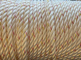 Close-up of a coiled rope with red and yellow strands on a wooden surface
